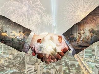 Hands shaking with happy fireworks in the background